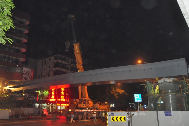 长38米、重达87吨的钢箱梁，被200吨吊车稳稳地吊装在两个桥梁墩柱之上